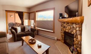 uma sala de estar com lareira e televisão em Cozy Winter Wonderland Getaway em Canmore