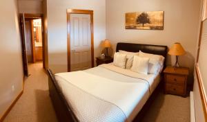 um quarto com uma cama com lençóis brancos e almofadas em Cozy Winter Wonderland Getaway em Canmore