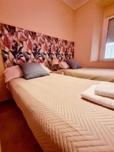 1 dormitorio con 2 camas en una habitación con papel pintado en Bonito piso en calle Antolinez en Sevilla