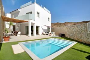 a villa with a swimming pool in front of a house at Escape to paradise luxury Poolvilla with ocieanview near Amadores in Mogán