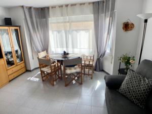 a living room with a table and chairs and a couch at Blanes old town: 2 blocks/2 min walk to the beach in Blanes