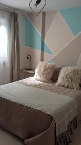 1 dormitorio con 1 cama con 2 almohadas peludas en Dolce Casa Departamentos en Neuquén