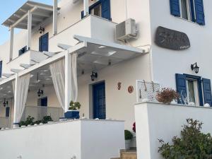 un edificio blanco con puertas y ventanas azules en Stolidi en Adamas