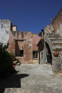 um beco num antigo edifício de pedra com uma porta em Evanthea Residence em Kounoupidhianá