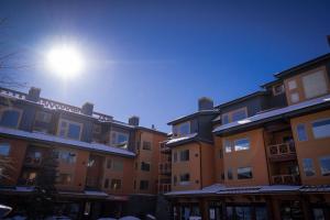 uma linha de edifícios com o sol no céu em Cozy Winter Wonderland Getaway em Canmore