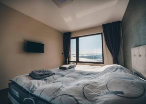 een groot bed in een kamer met een raam bij LUXURY APARTAMENT NEAR THE SEA in Varna
