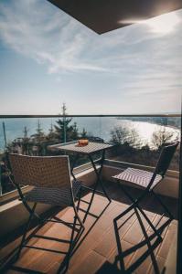 twee stoelen en een tafel op een balkon met uitzicht op het water bij LUXURY APARTAMENT NEAR THE SEA in Varna