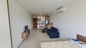 sala de estar con sofá azul y cocina en Acqua Vert Residence & Loft - Em frente a Praia de Armação e Centro de Convenções, en Salvador