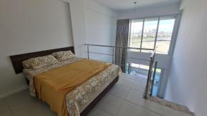 1 dormitorio con cama y ventana grande en Acqua Vert Residence & Loft - Em frente a Praia de Armação e Centro de Convenções, en Salvador