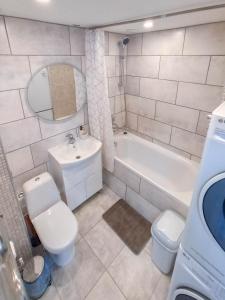 a bathroom with a toilet and a tub and a sink at Apartamentai ramioje vietoje in Šiauliai