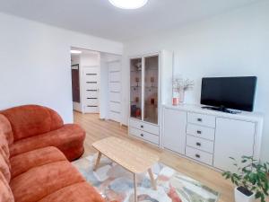 ein Wohnzimmer mit einem Stuhl und einem TV in der Unterkunft Apartamentai ramioje vietoje in Šiauliai
