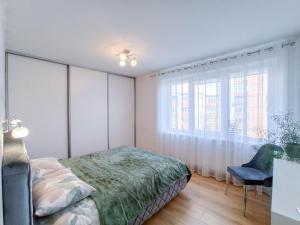Schlafzimmer mit einem Bett und einem Fenster in der Unterkunft Apartamentai ramioje vietoje in Šiauliai