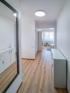 ein leeres Zimmer mit weißen Wänden und einem großen Spiegel in der Unterkunft Apartamentai ramioje vietoje in Šiauliai