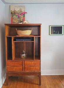 a wooden book shelf with a basket on top of it at The Sailing Gypsy and Bunkie incl in pricing June 22-Sept 14 in Port Elgin