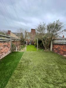 einen Hof mit Ziegelwand und einem Gebäude in der Unterkunft Fayhomes West Midlands Luxury Late 1800 Property in Walsall