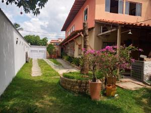 a house with pink flowers in a yard at Casa Vilar Rio Temporada Barreirinhas Lencois Maranhenses in Barreirinhas