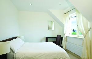 a white bedroom with a bed and a window at Ring Of Kerry HC No 20 in Kenmare