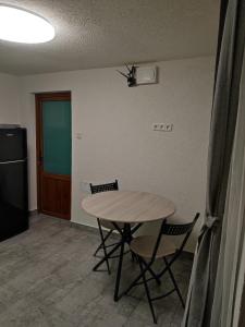 a kitchen with a table and two chairs and a refrigerator at Torok Adrian Mihail PFA in Râşnov