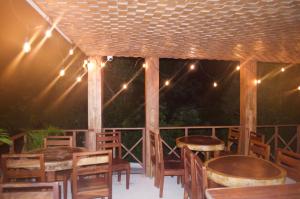 un patio con mesas de madera, sillas y luces en Lagoon Boutique Hotel - Luxury Chaman experience, en Tulum