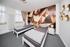a bedroom with two beds and a wall with mirrors at Anhalt Pension in Coswig