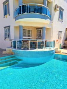 a building with a swimming pool in front of a house at Three Bed villa, Private Pool in Didim
