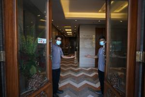 Dwóch mężczyzn w maskach na korytarzu hotelowym. w obiekcie Palm Boutique Hotel w mieście Dżudda