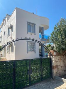 a white house with a gate in front of it at Three Bed villa, Private Pool in Didim