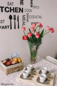 una mesa con un jarrón de flores y una cesta de comida en Case Vacanze Paola en Santo Stefano al Mare