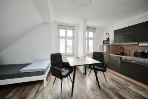 a kitchen with a table and chairs in a room at Anhalt Pension in Coswig