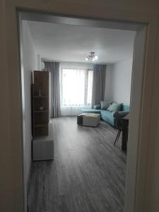 ein Wohnzimmer mit einem blauen Sofa und einem Tisch in der Unterkunft Апартамент Памела ВИП гр. Добрич in Dobritsch