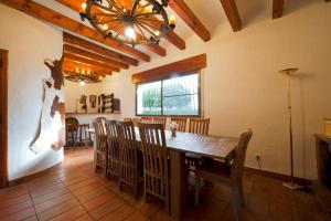 comedor con mesa, sillas y lámpara de araña en Villa Bovalar, en Polop
