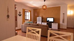 a living room with a couch and a tv at Casa BARCA DO SOL in Vila Nova de Milfontes