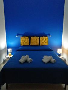 um quarto azul com uma cama com paredes azuis e almofadas amarelas em a casa di Dina em Purgatorio