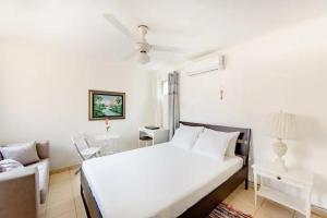 una camera bianca con un letto e un divano di Rincón Caribeño Habitación Privada a Santo Domingo