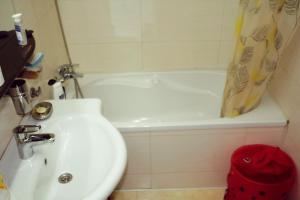 a bathroom with a sink and a tub and a toilet at City center Deluxe apartment in Bucharest