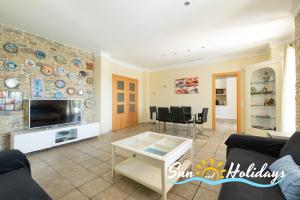 a living room with a couch and a tv at Villa Oasis in El Vendrell
