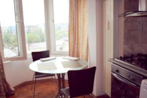 a table and chairs in a kitchen with a window at City center Deluxe apartment in Bucharest