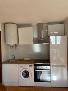 een keuken met een witte koelkast en een wasmachine bij Piso a 50m de la Playa en Somo con Garaje Privado in Somo