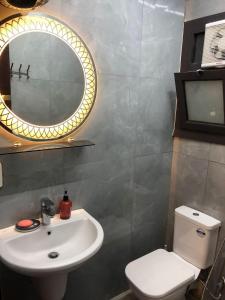 La salle de bains est pourvue d'un lavabo, d'un miroir et de toilettes. dans l'établissement بورتو سعيد Portosaid, à Port-Saïd