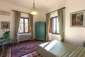 a bedroom with a bed and a table and windows at Hotel Villa Porta All'Arco in Volterra