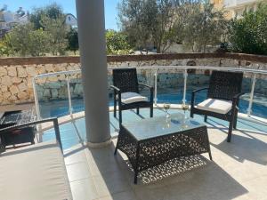 a patio with two chairs and a table and a pool at Three Bed villa, Private Pool in Didim