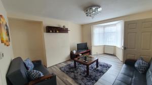 sala de estar con sofá y TV en Spacious 3-bedroom home in Birmingham with driveway parking en Birmingham