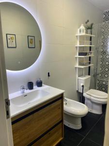 a bathroom with a sink and a toilet and a mirror at Casa da Monservia in Sintra +51 photos
