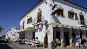 a group of people sitting outside of a building at Casa BARCA DO SOL in Vila Nova de Milfontes