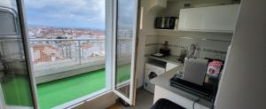 Cette chambre dispose d'une grande fenêtre offrant une vue sur la ville. dans l'établissement PLEIN SUD Terrasse Panoramique Climatisation Garage Netflix, à Lyon