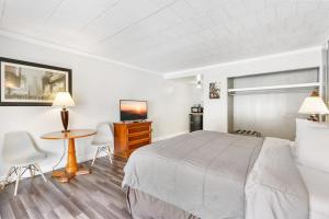 ハイランドフォールズにあるFairBridge Inn and Suites West Pointのベッド、テーブル、椅子が備わるホテルルームです。