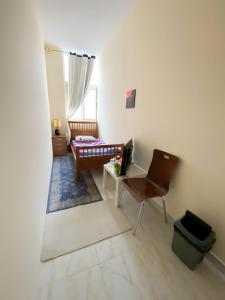Habitación con escritorio, silla y cama. en MBZ - Relax Room in Unique Flat en Abu Dabi