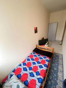 a bedroom with a bed with red and blue flowers at MBZ - Relax Room in Unique Flat in Abu Dhabi