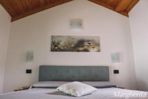 1 dormitorio con 1 cama y una pintura en la pared en Case Vacanze Paola en Santo Stefano al Mare