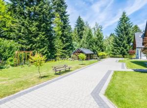 un parque con banco y parque infantil en Domki Letniskowe SOBALSKI, en Zawoja